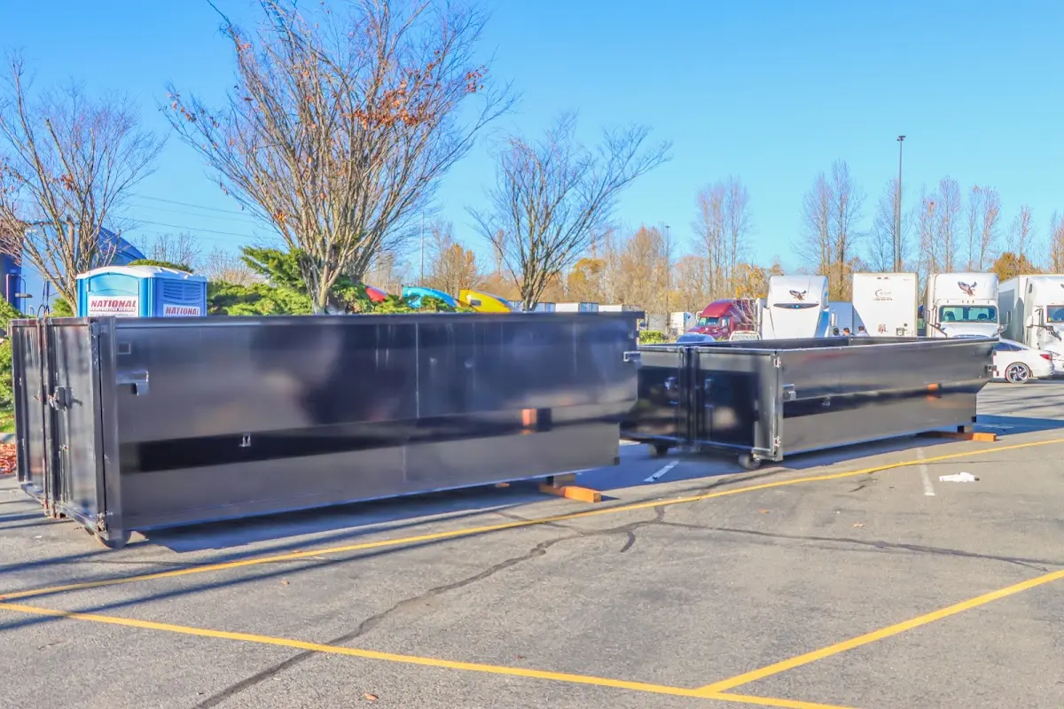 Professional dumpster rental service with roll-off container on residential driveway in Huntington